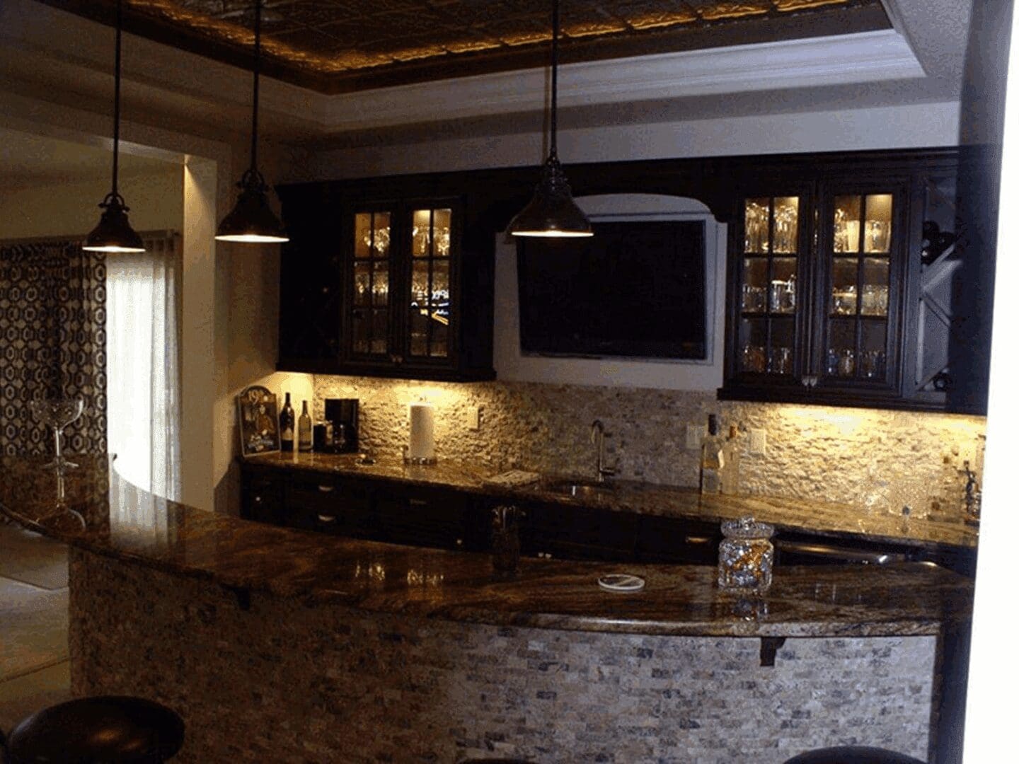 Home bar with stone counter and cabinets
